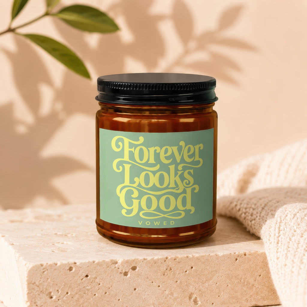 Brown glass jar with black lid bearing "Forever Looks Good vowed" text.