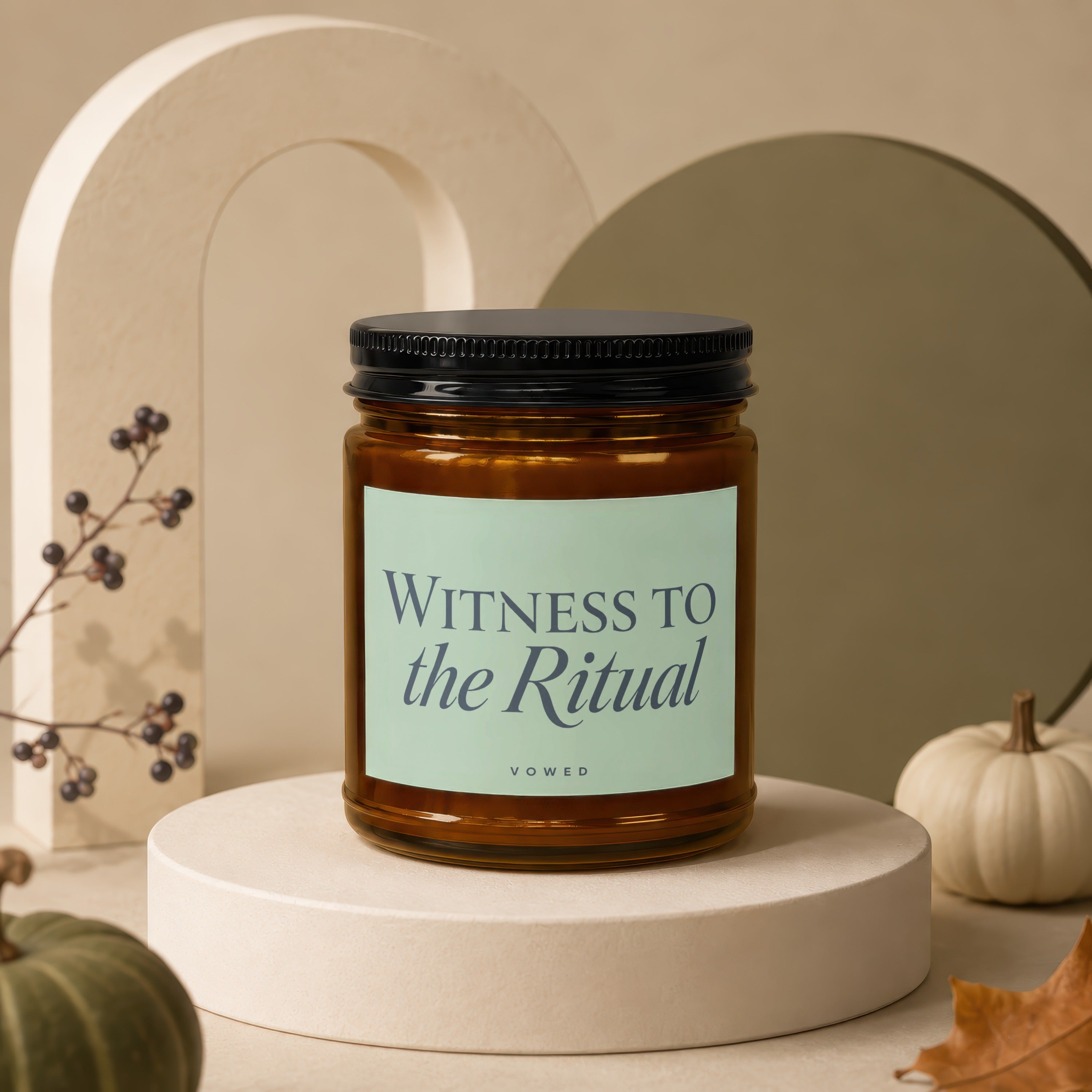 Amber jar candle with black lid, "Witness to the Ritual Vowed" label, on a pedestal.