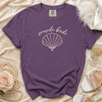 Purple t-shirt with "seaside bride" text and a seashell graphic.