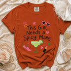 Orange t-shirt with "This Girl Needs a Spicy Marg" graphic, margarita, and chili peppers.