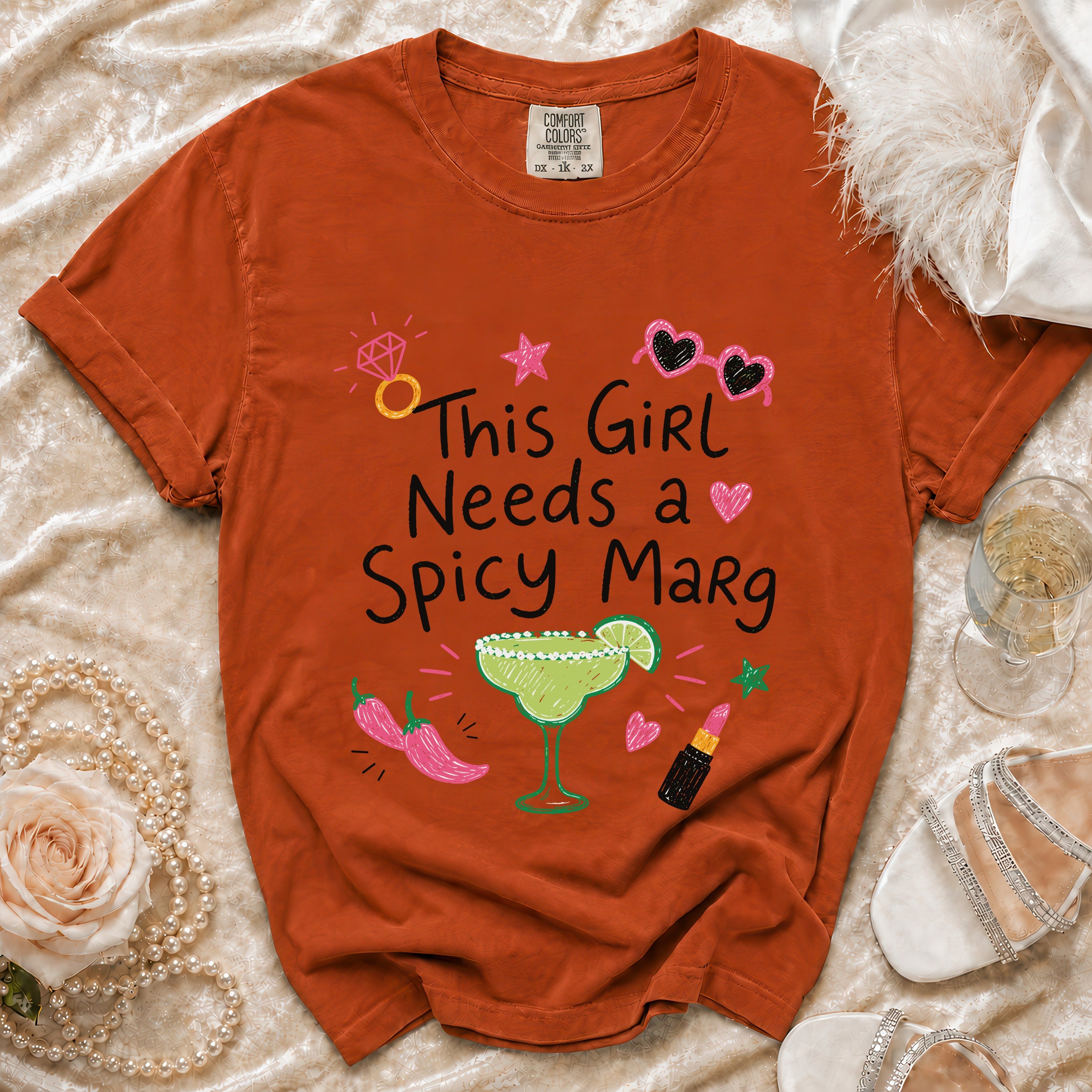Orange t-shirt with "This Girl Needs a Spicy Marg" graphic, margarita, and chili peppers.