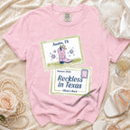 Pink t-shirt with Austin, TX and Reckless in Texas graphics.