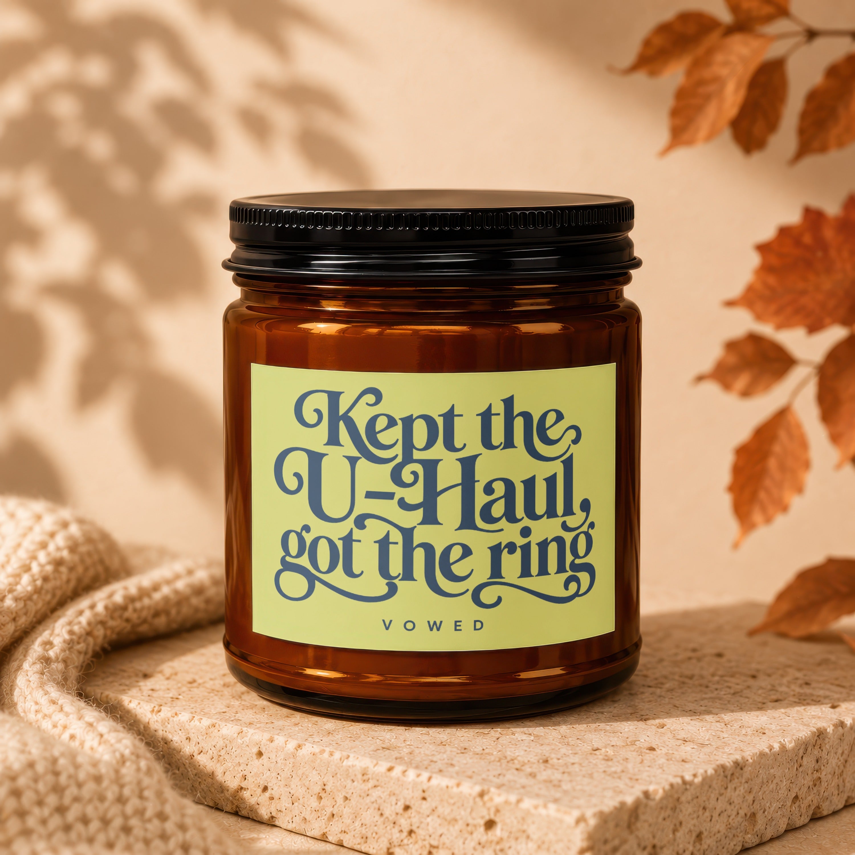 Amber jar candle with text "Kept the U-Haul, got the ring" and "VOWED".