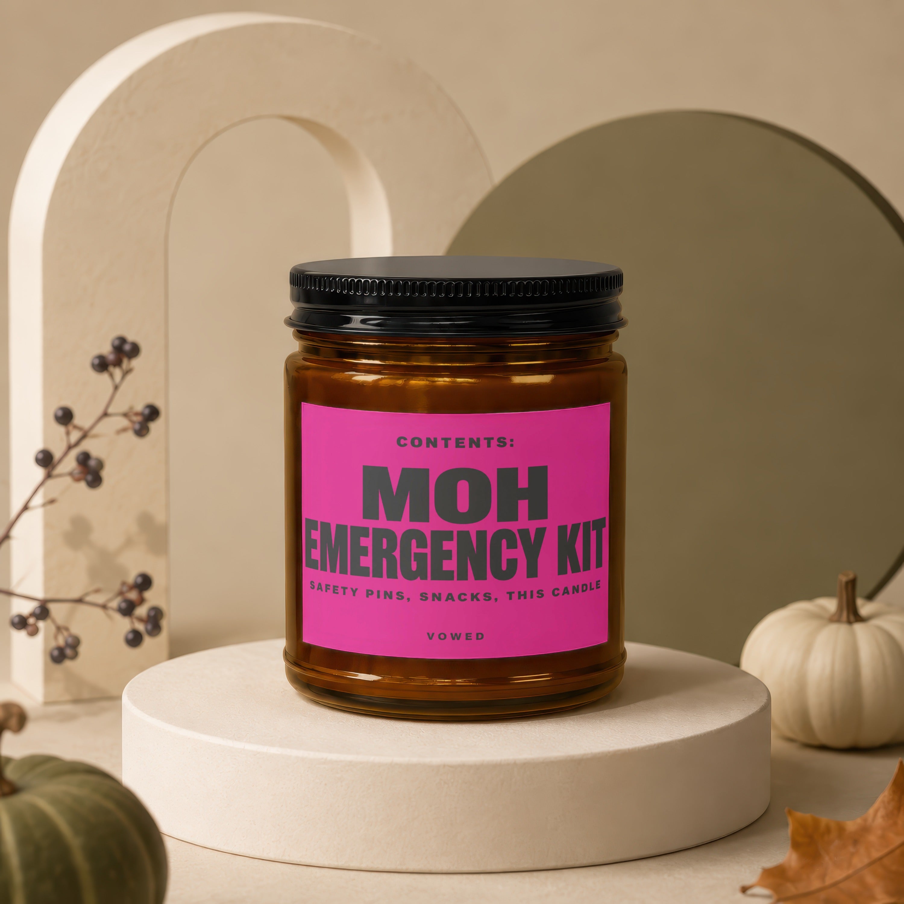 Amber candle labeled "MOH Emergency Kit" with contents: "Safety Pins, Snacks, This Candle."