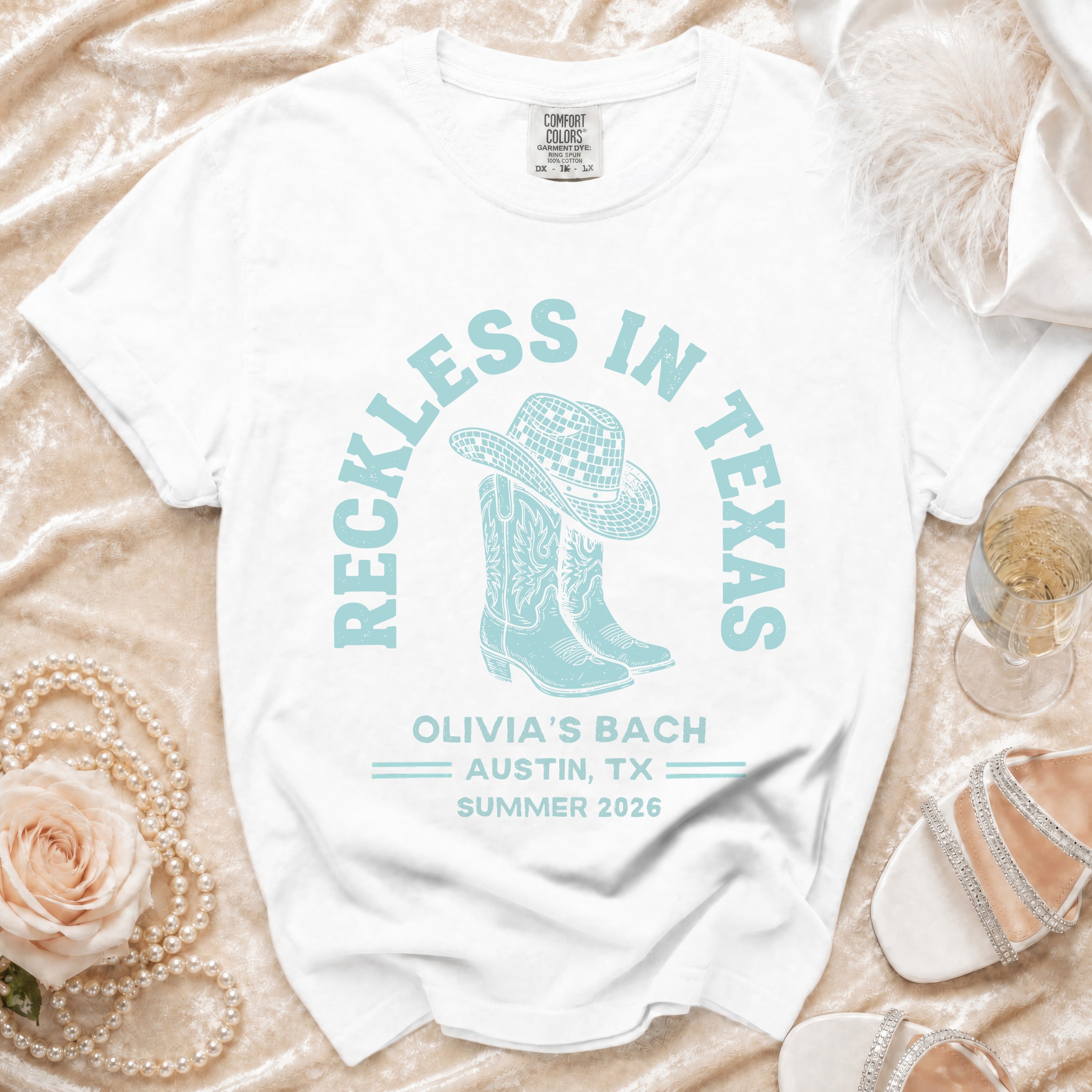 White t-shirt with "Reckless in Texas" and "Olivia's Bach Austin, TX Summer 2026" text.