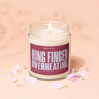 Candle with "Ring Finger Overheating" warning label, surrounded by pink petals.