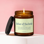 Lit amber candle with "father of the bride" definition on label.