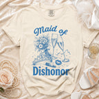 Cream t-shirt with blue "Maid of Dishonor" text, bouquet, tiara, lipstick, and champagne flutes.