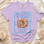 T-shirt with "Reckless in Texas" and "Olivia's Bach Austin, TX Summer 2026" text.