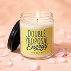Lit glass jar candle with yellow label reading "Double Proposal Energy VOWED".