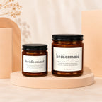Two bridesmaid candles with definition labels on a light pink stage.