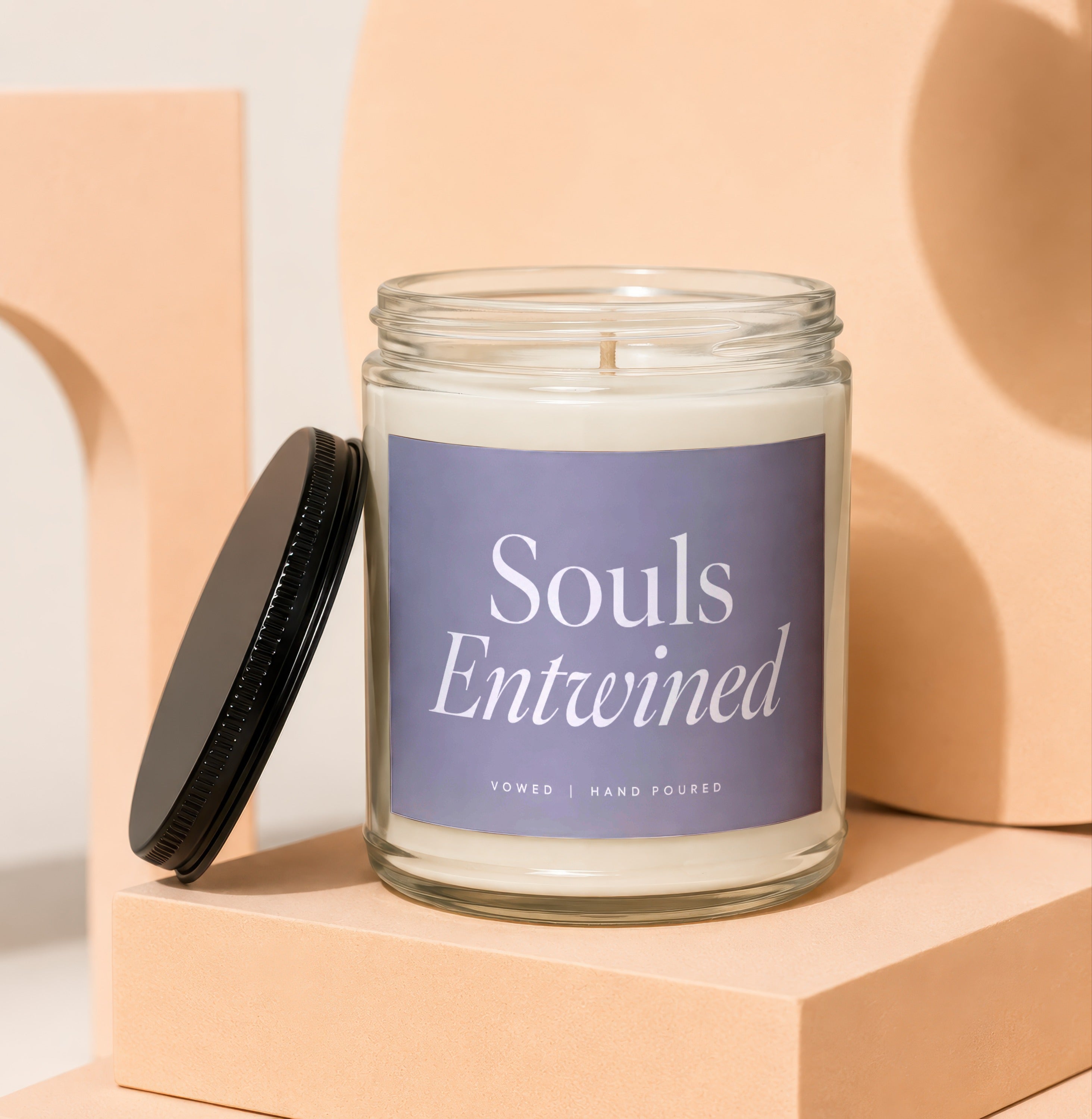 Glass candle with "Souls Entwined" label and black lid.