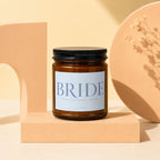 Amber jar candle with a white label that reads "BRIDE" and "VOWED".