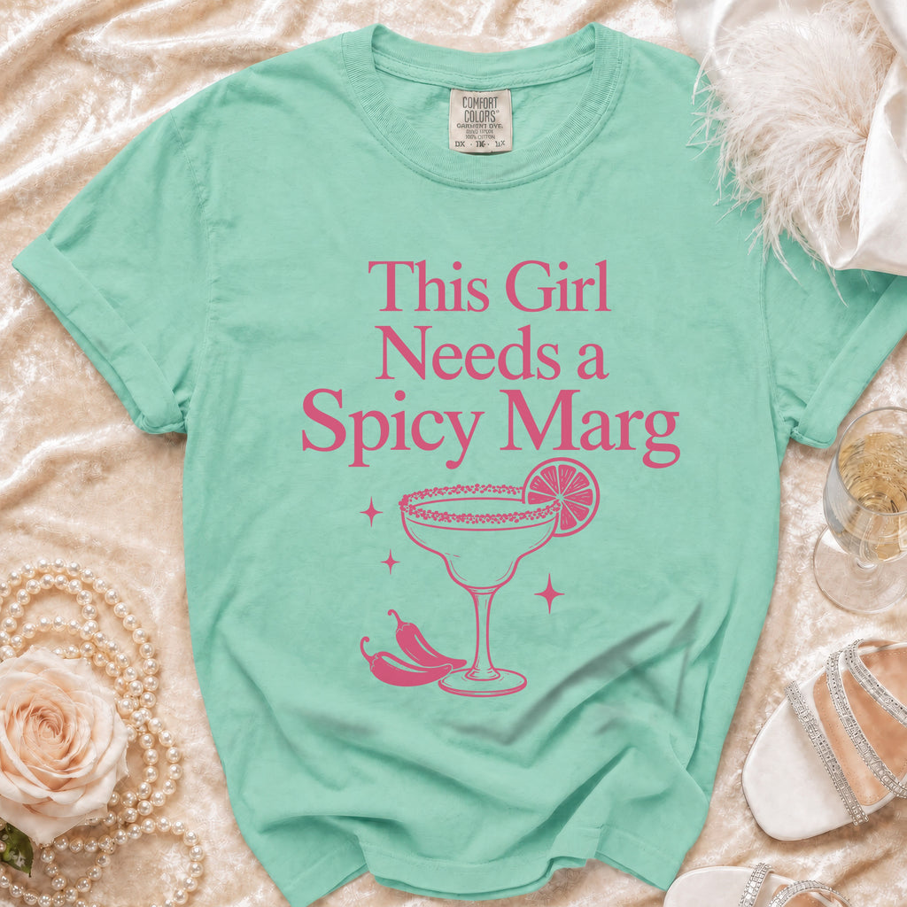 Mint green t-shirt with pink text "This Girl Needs a Spicy Marg" and graphic.
