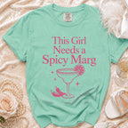 Mint green t-shirt with pink text "This Girl Needs a Spicy Marg" and graphic.