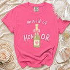 Pink t-shirt with "Maid of Honor" text and champagne bottle graphic.