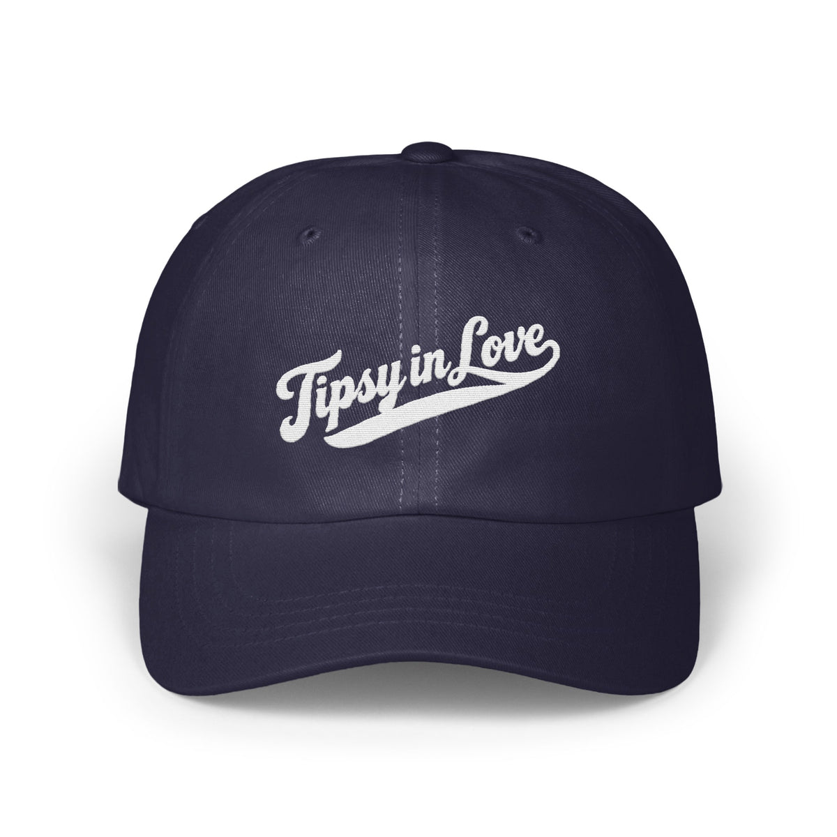 A dark navy blue baseball cap with embroidered white text reading Tipsy in Love on the front.