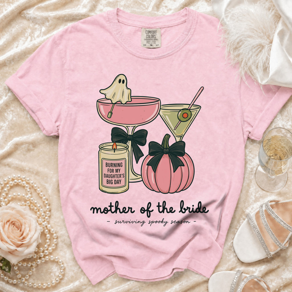 Pink t-shirt with ghost, drinks, pumpkin, and candle design. "Mother of the bride - surviving spooky season."
