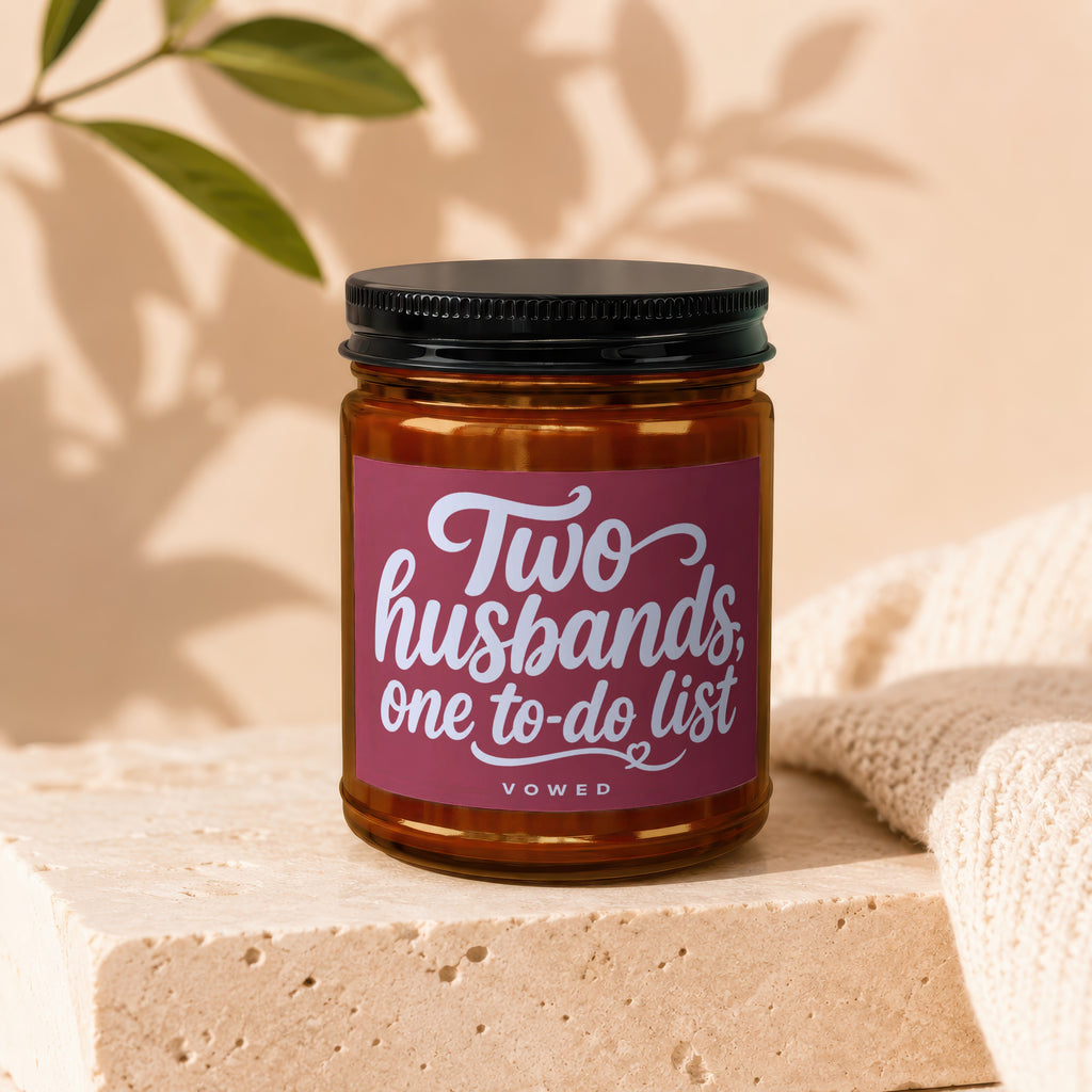 Candle with black lid, maroon label reading "Two husbands, one to-do list" and "VOWED".