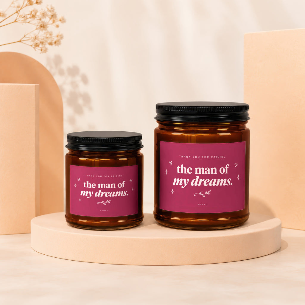 Two amber glass candles with pink labels that read "Thank You For Raising the man of my dreams."