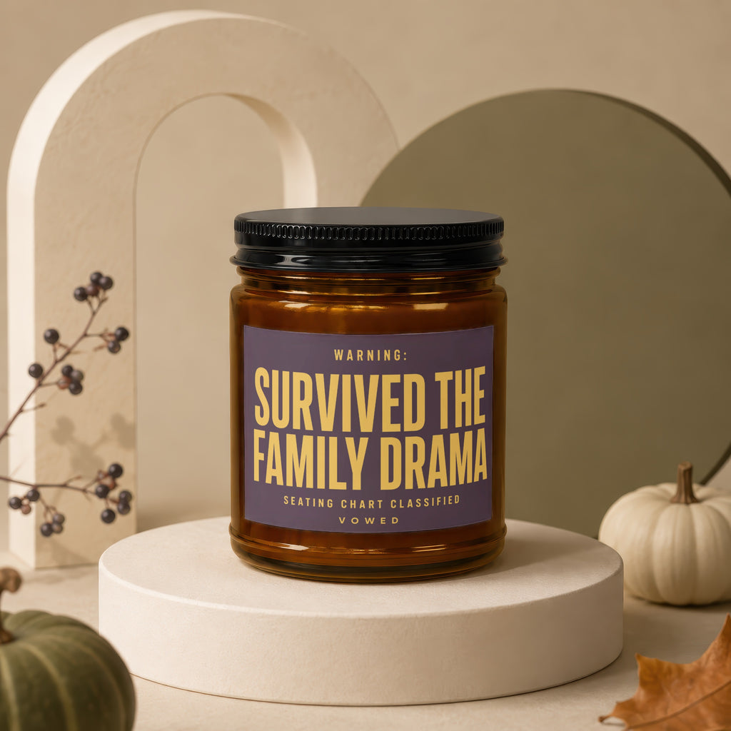Amber jar candle with black lid labeled "Survived the Family Drama".