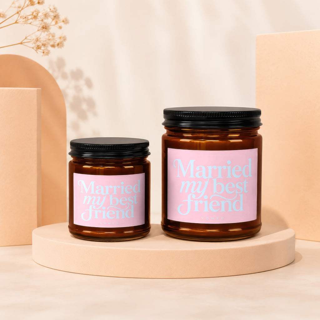 Two amber glass candles with pink labels reading "Married my best friend."
