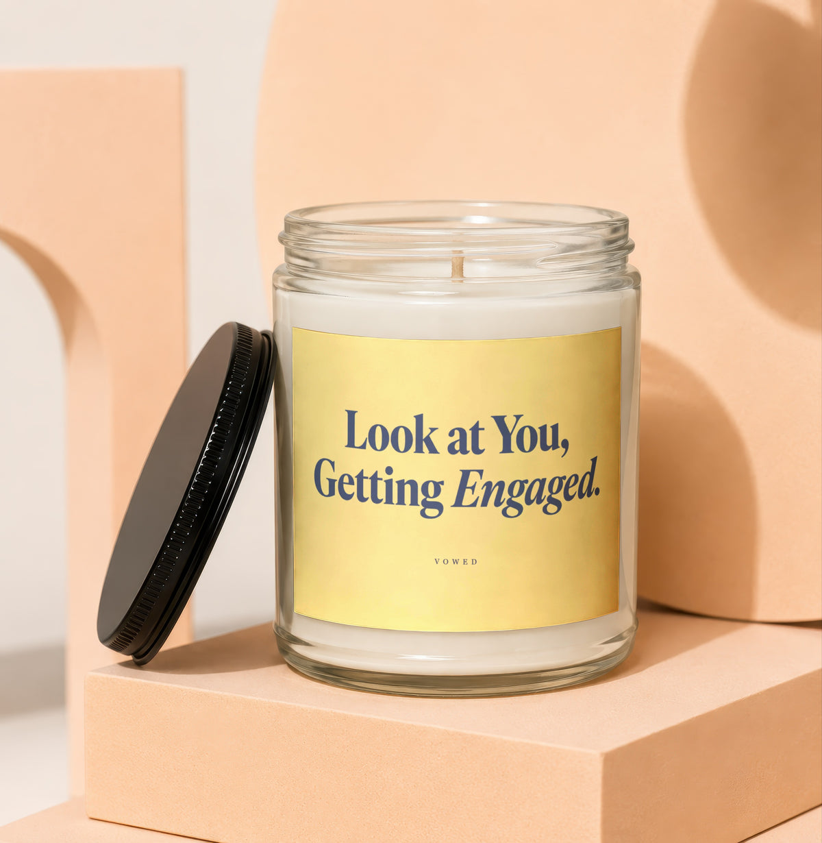 Candle with "Look at You, Getting Engaged." text on a yellow label.
