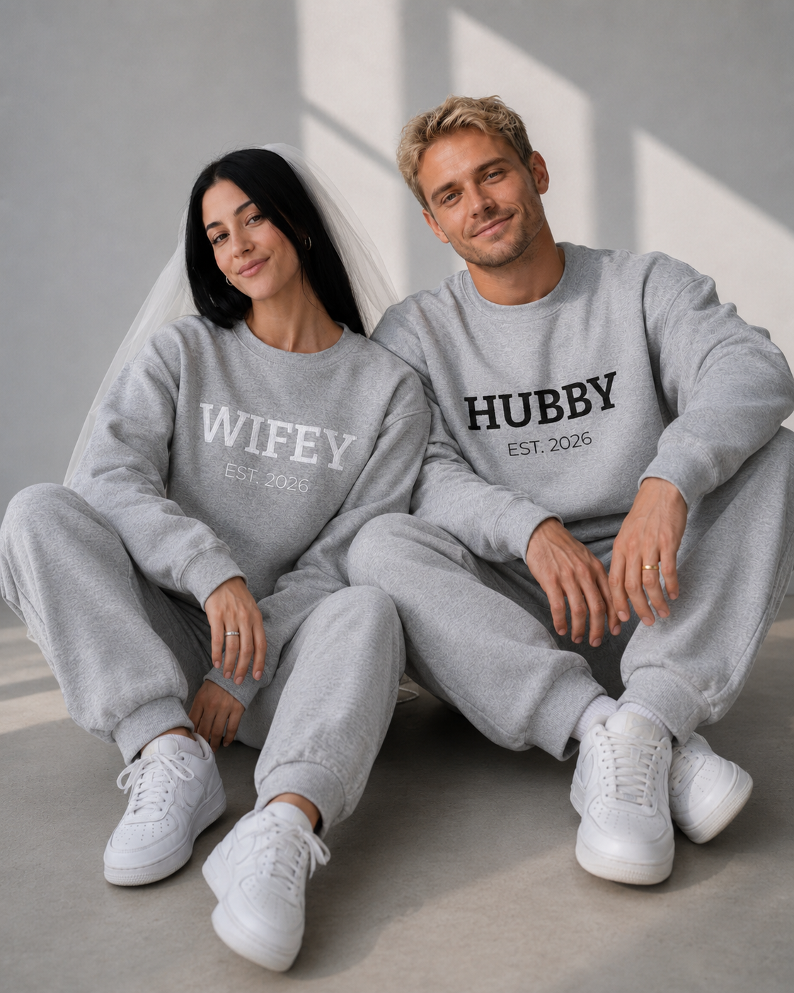 Couple in matching embroidered Hubby and Wifey sweatshirts
