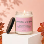 Candle with "grandmother of the groom" text, lid off, lit wick.