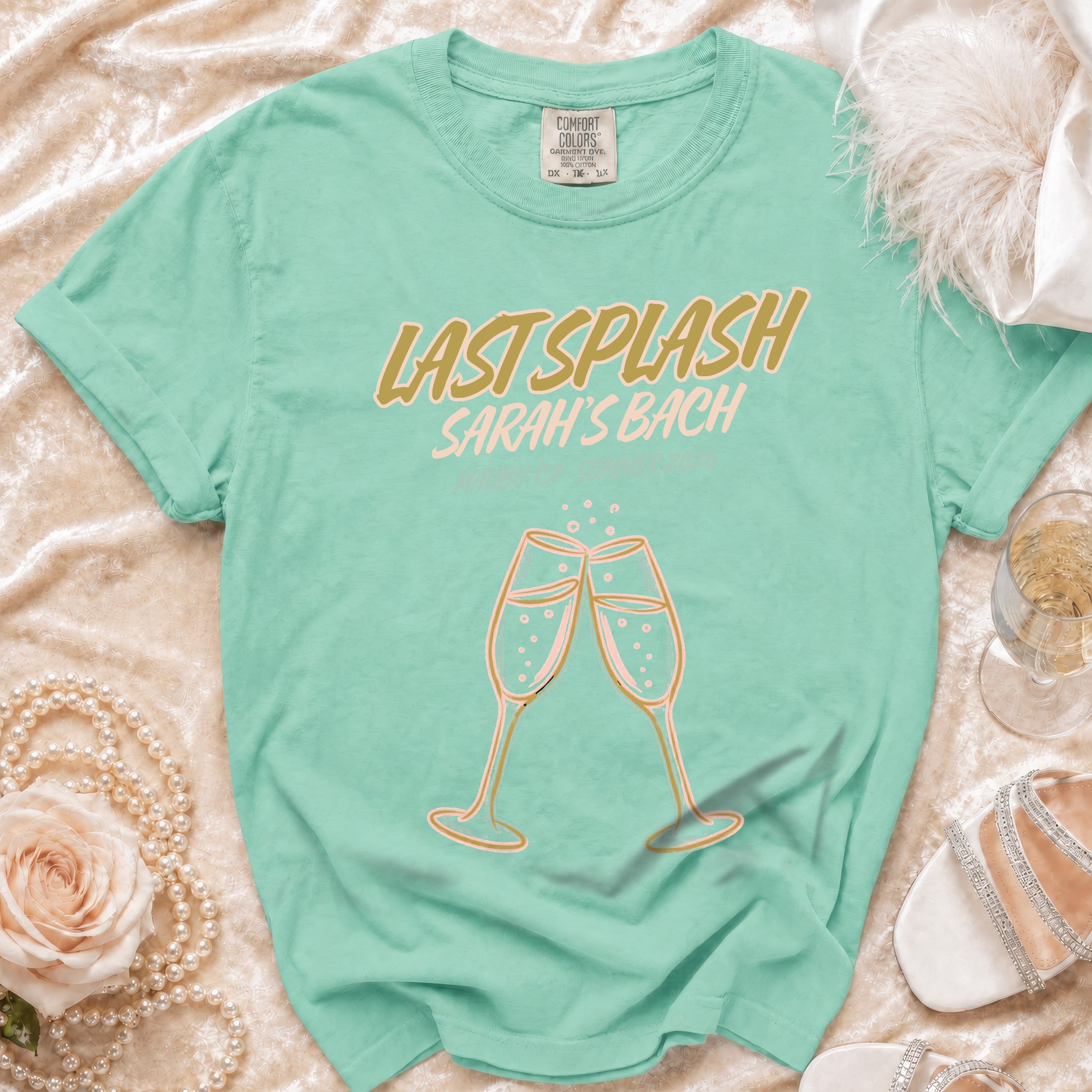 Mint green t-shirt with "Last Splash Sarah's Bach" and clinking champagne glasses.