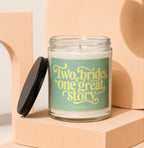 Glass candle with a green label that reads "Two brides, one great story."