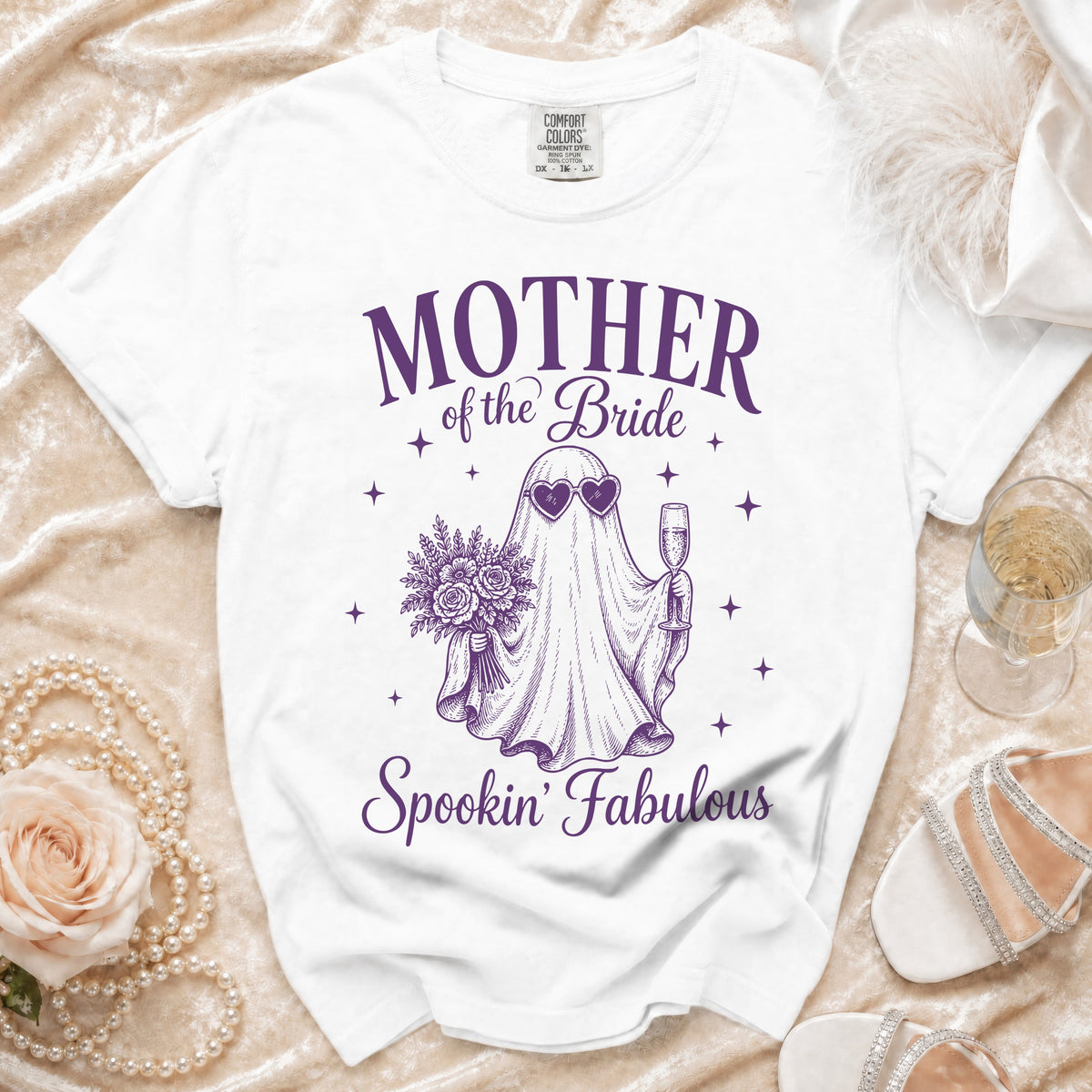 White t-shirt with purple text and ghost graphic reading "Mother of the Bride Spookin' Fabulous".
