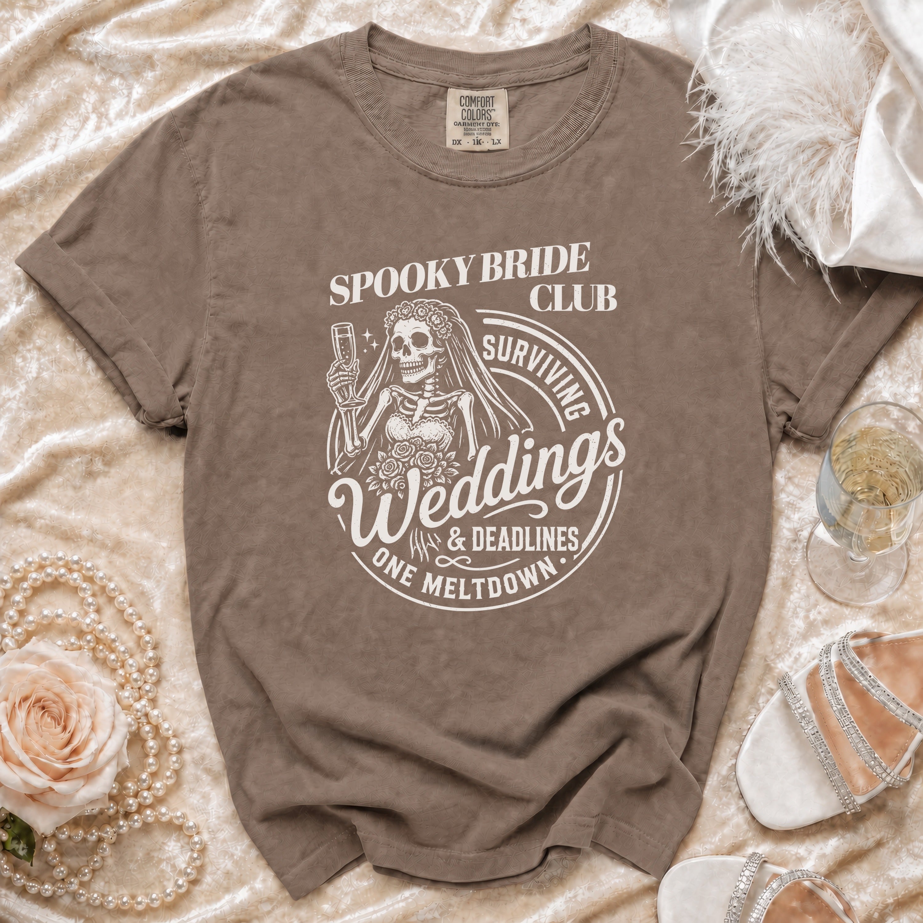 Brown t-shirt with "Spooky Bride Club Surviving Weddings & Deadlines One Meltdown" graphic.