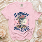 Pink t-shirt with a skeleton hand holding a bouquet, bats, and text.