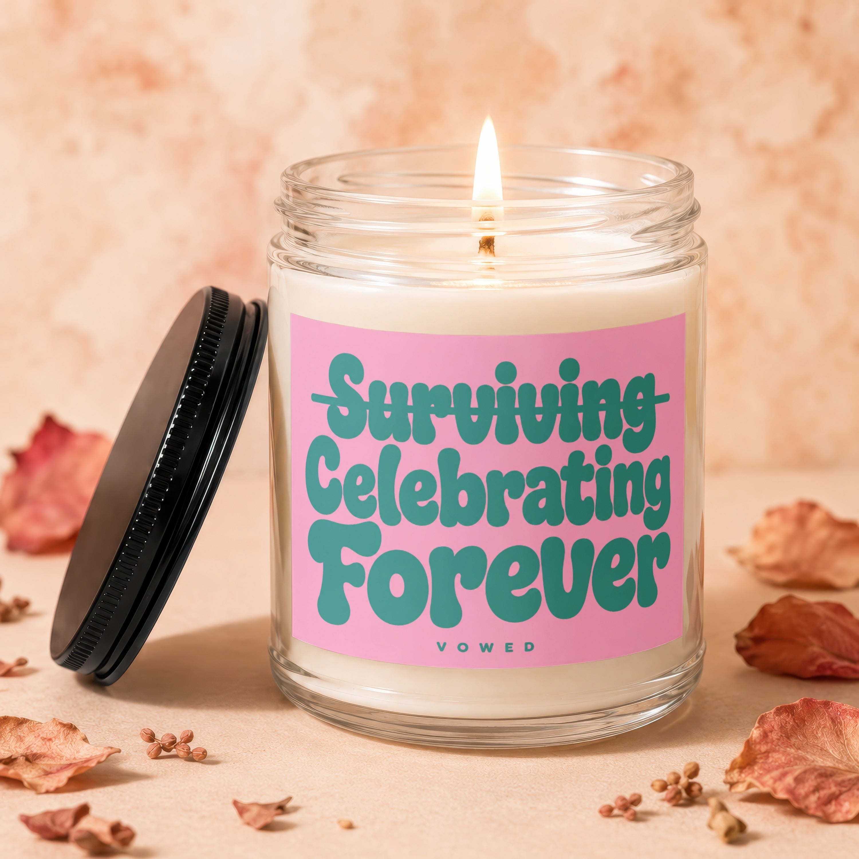 Glass candle with pink label reading "Surviving Celebrating Forever" and "VOWED".
