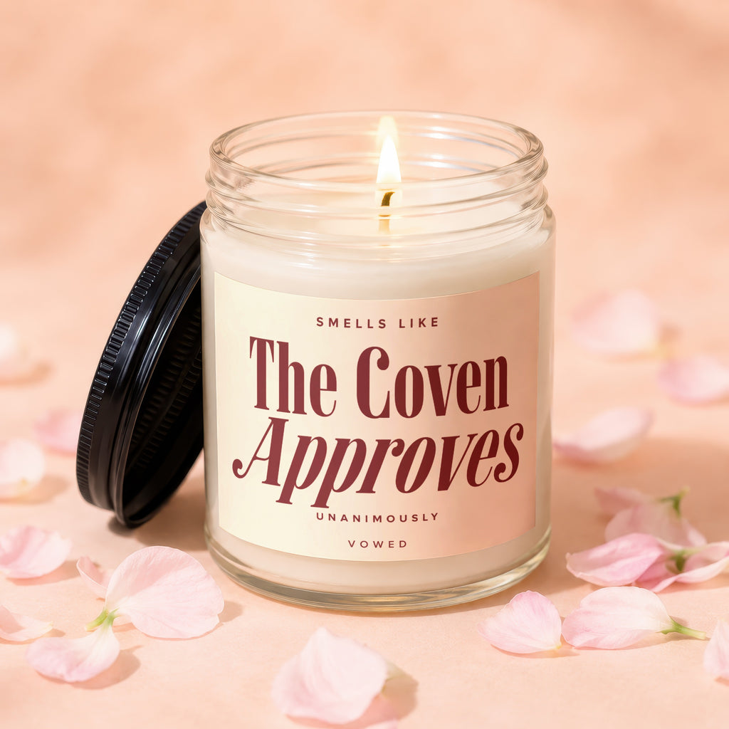 Candle with label "Smells like The Coven Approves".