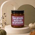 Candle with "Two grooms, no bride, no problem" text on pink label.