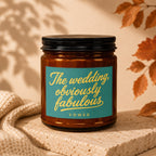 Amber glass candle with teal label reading "The wedding, obviously fabulous."