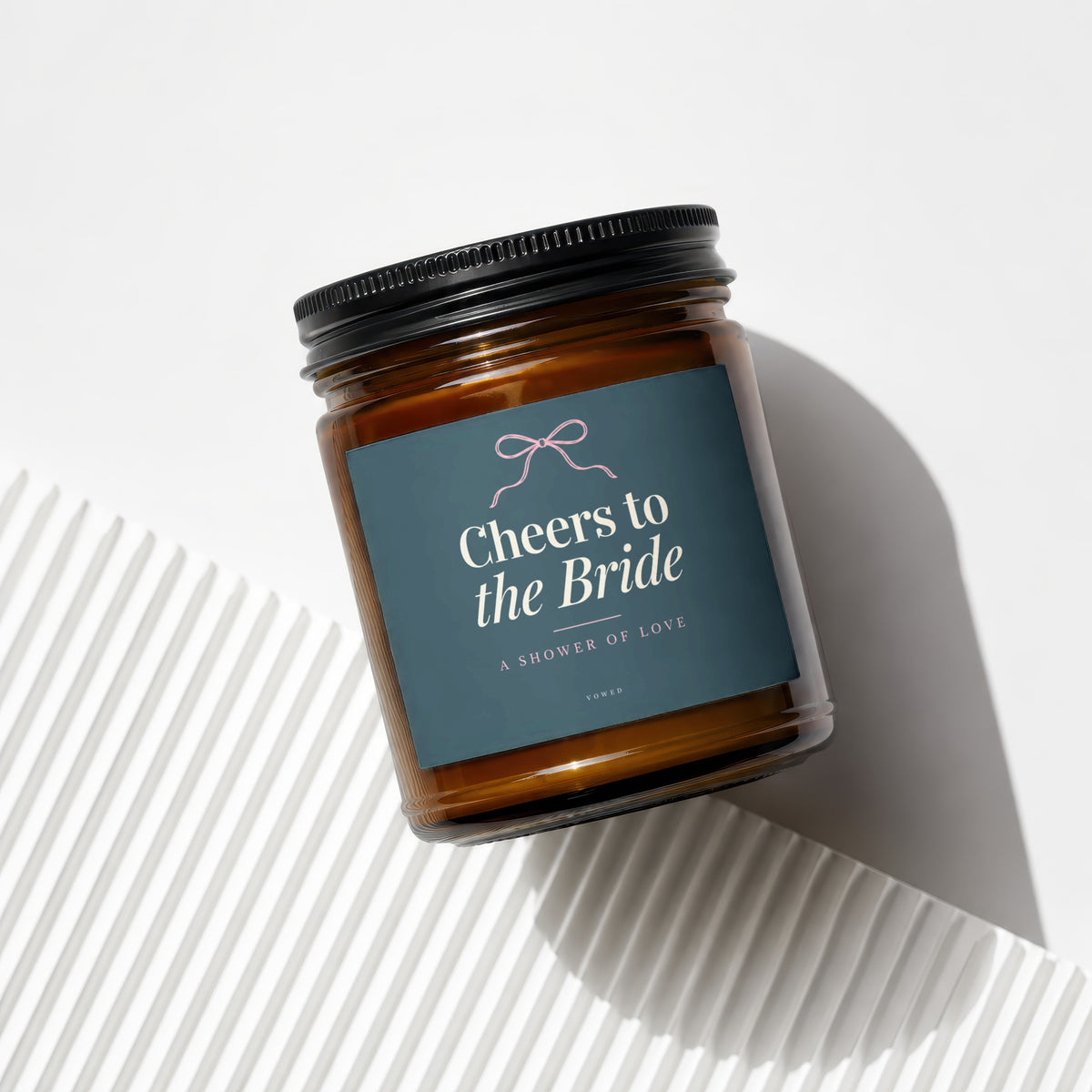 Amber candle with a dark blue label that reads "Cheers to the Bride".