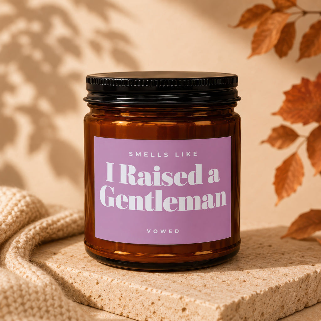 Brown glass candle with a lavender label reading "Smells Like I Raised a Gentleman."