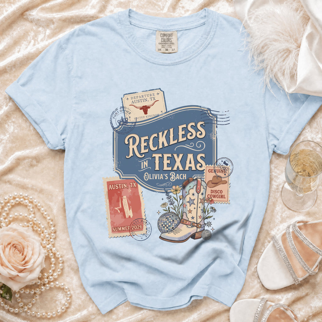 Light blue t-shirt with "Reckless in Texas" graphic and cowboy boot.