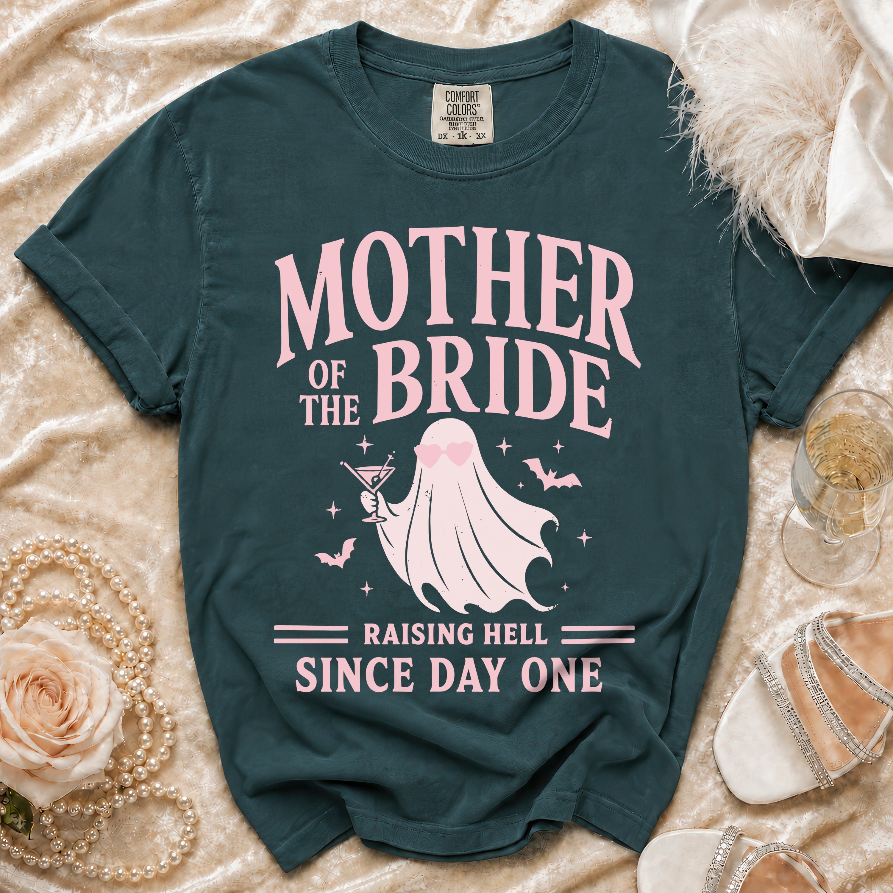 Teal t-shirt with "Mother of the Bride Raising Hell Since Day One" text and a ghost graphic.