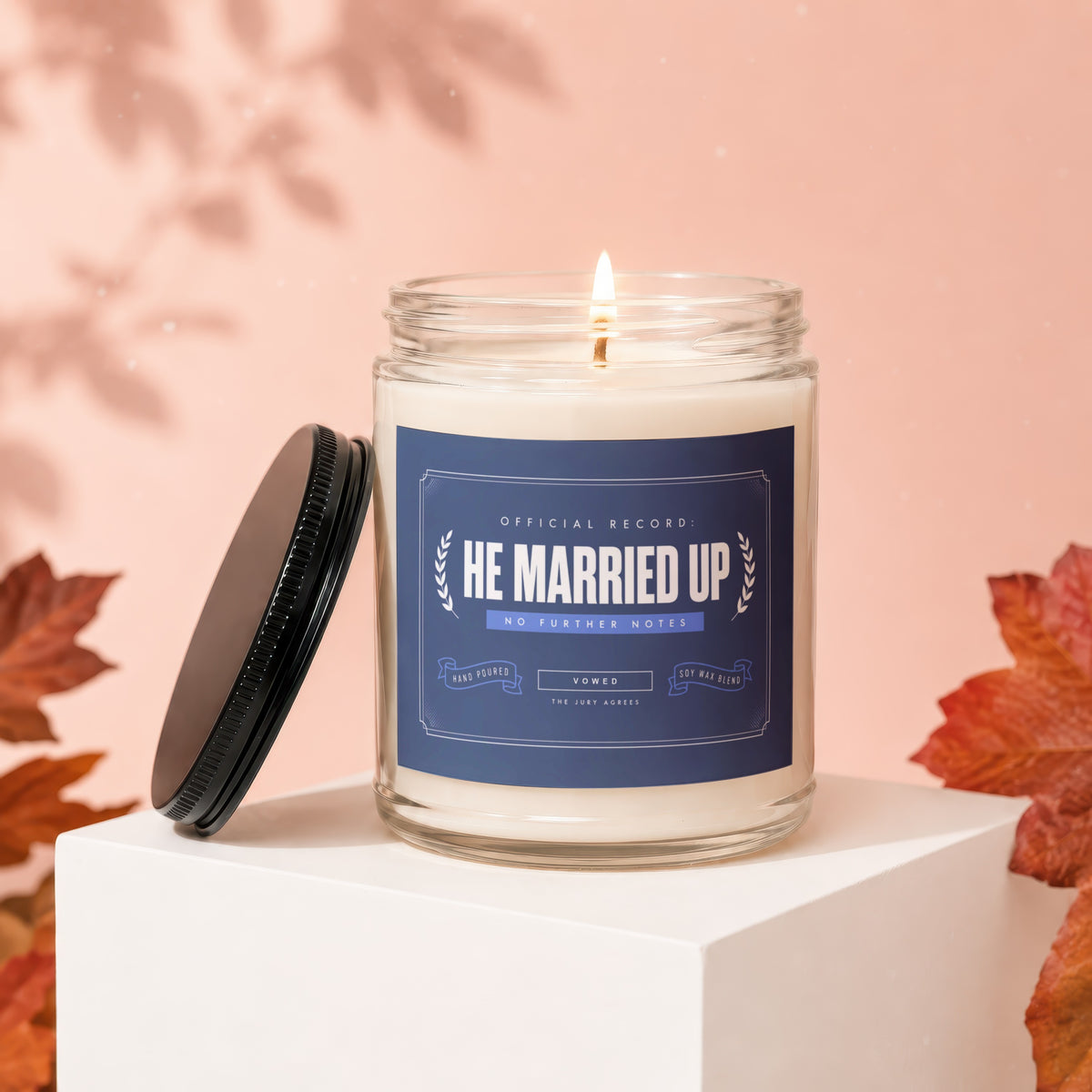 Lit candle in jar with label "He Married Up, No Further Notes, Vowed, The Jury Agrees".