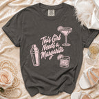 Dark grey t-shirt with "This Girl Needs a Margarita" text, a margarita glass, and shaker.