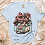Light blue t-shirt with a graphic of a newlywed couple in a convertible with "Just Hitched & Unsupervised" text.
