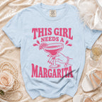 Light blue t-shirt with "This Girl Needs A Margarita" graphic and a margarita glass.