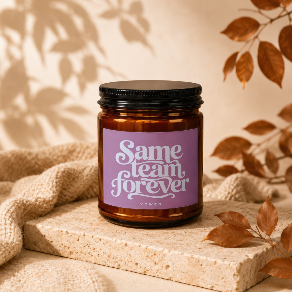 Amber candle with "Same team forever" text on a purple label.