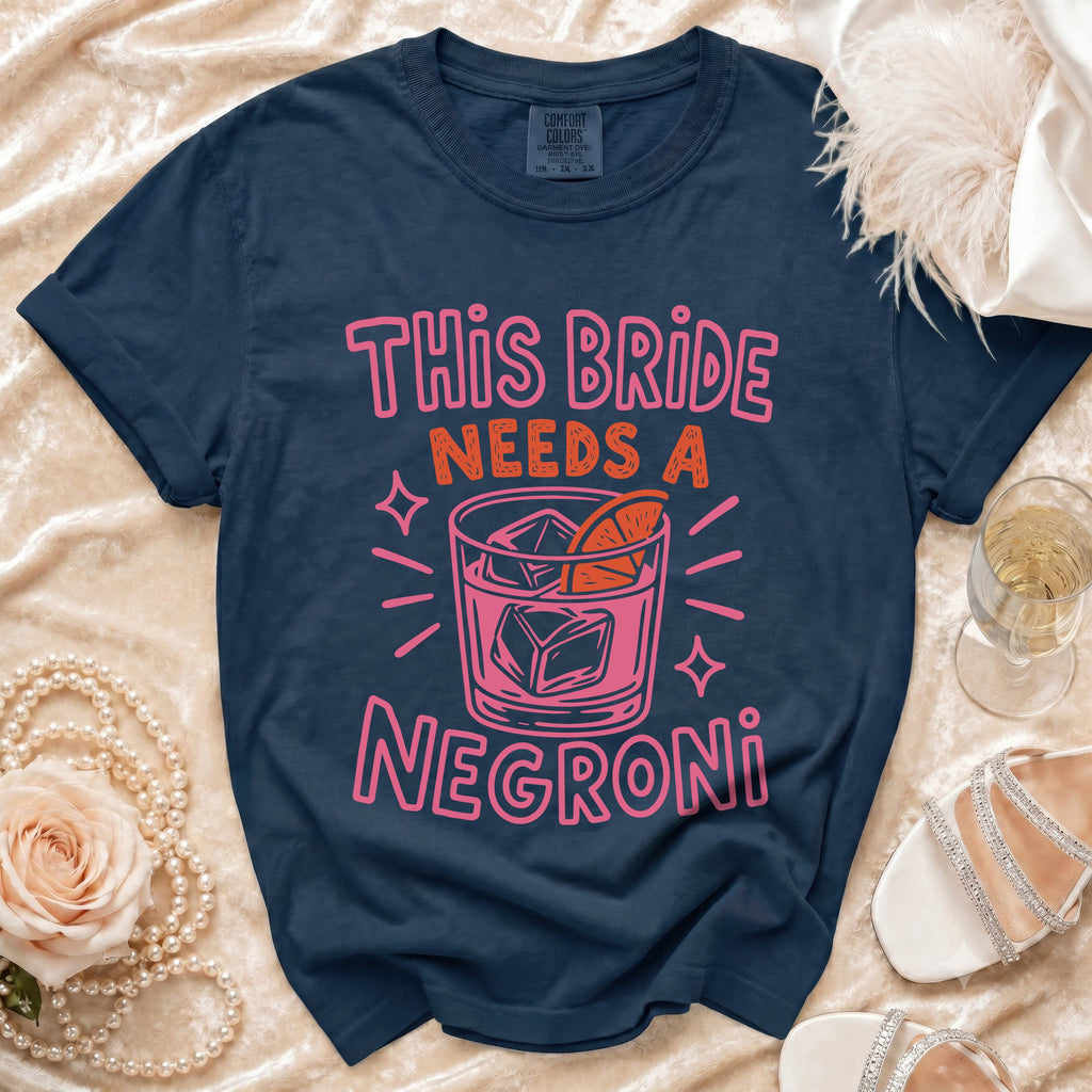 Navy t-shirt with pink text "This bride needs a negroni" and cocktail graphic.