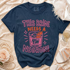 Navy t-shirt with pink text "This bride needs a negroni" and cocktail graphic.