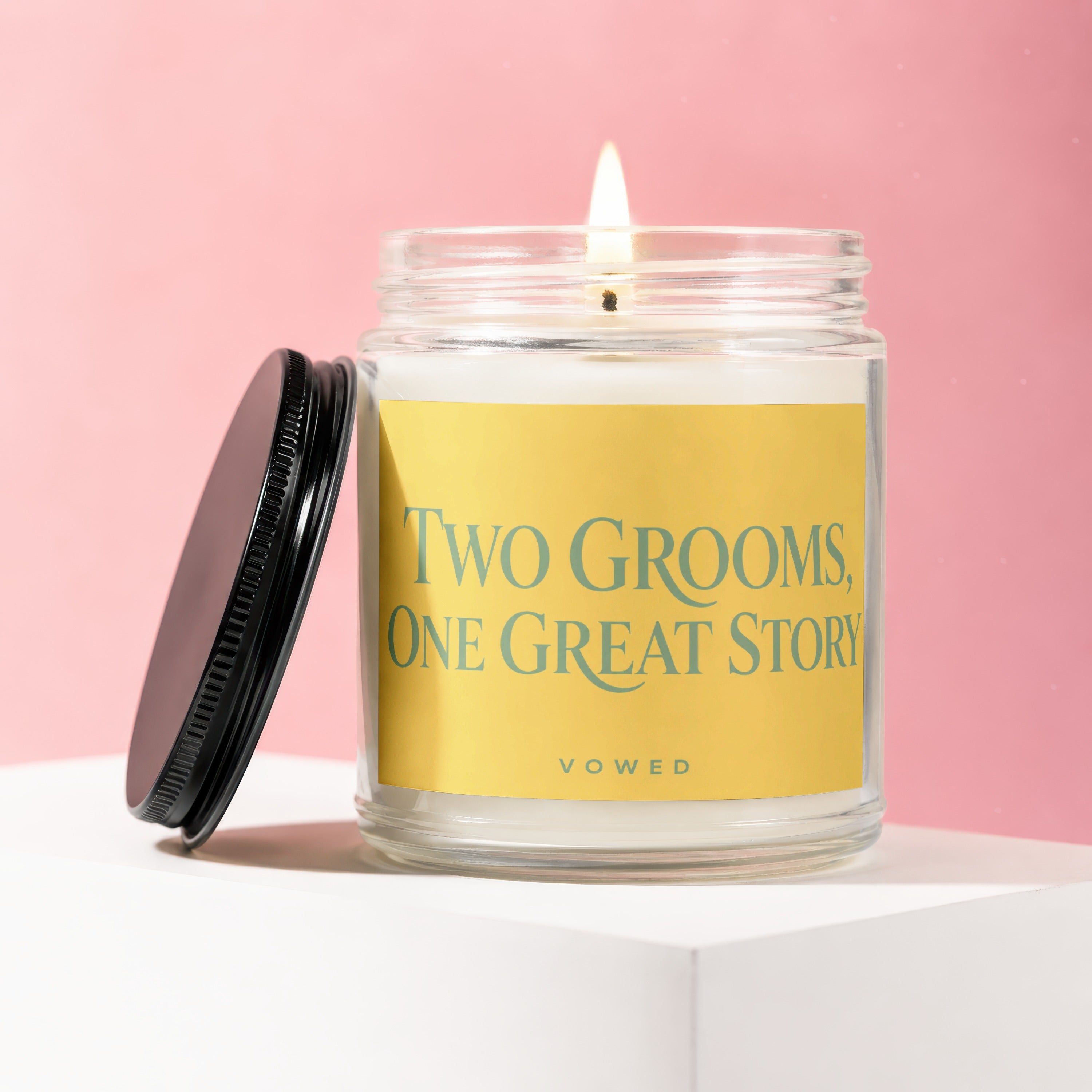 Lit candle in glass jar with "Two Grooms, One Great Story" text and "Vowed" subtitle.